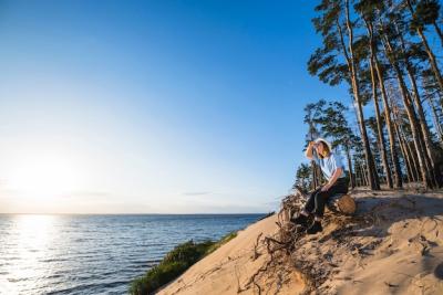 Woman Sitting on Log and Looking at Distance