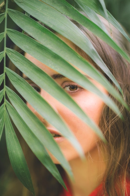 Woman looking at camera through leaves