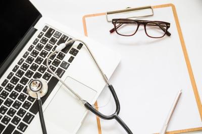 Stethoscope on Open Laptop with Clipboard and Eyeglasses – Free Download
