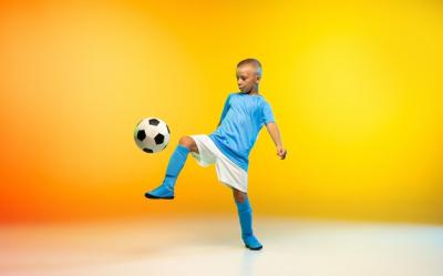 Young boy soccer football player sportwear practicing gradient yellow