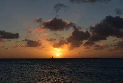 Sailboat sailing in front of the setting sun in Aruba