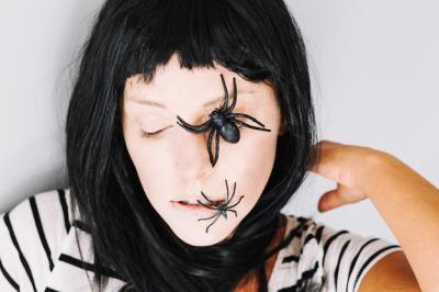 Gothic girl sleeping with spiders on face