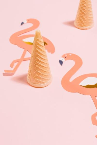 Waffle ice cream cones with flamingoes paper cut out on pink background