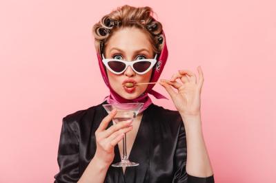 Portrait of a Woman with Curlers Eating Olive in Black Dress