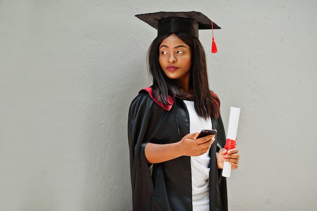 Young Female African American Student with Diploma and Mobile Phone Poses Outdoors