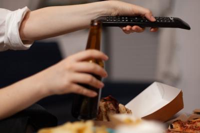 Closeup of woman hands changing channels using remote watching entertainment comedy movie