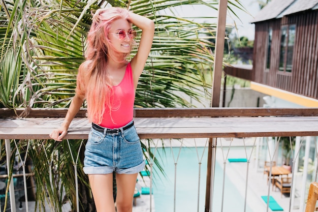 Stylish Summer Outfit: Wonderful Young Woman Posing on Exotic Background