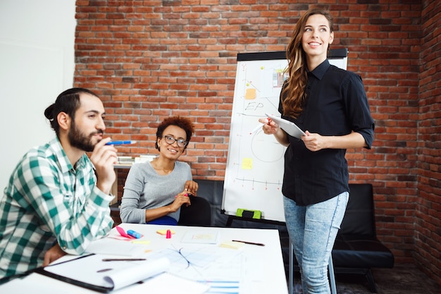 Girl giving presentation to colleagues at business meeting