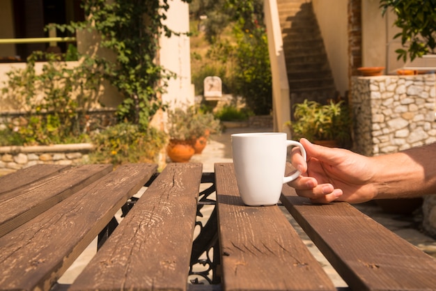 White Coffee Cup on Table with Outdoor Setting