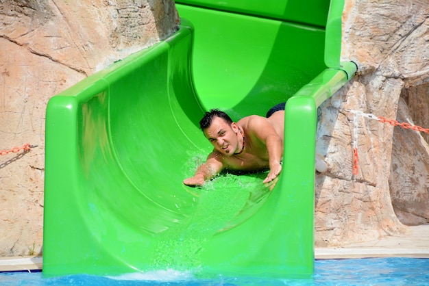 Guy on water slide during summer holiday – Free Stock Photo Download