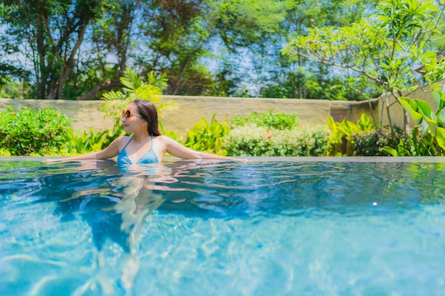 Portrait of a Beautiful Young Asian Woman Smiling Happily and Relaxing in the Swimming Pool