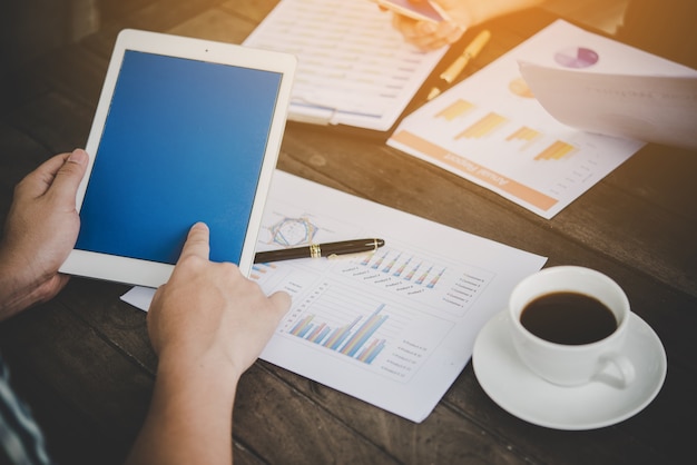 Businessman using tablet for analyzing business chart marketing report, working in office