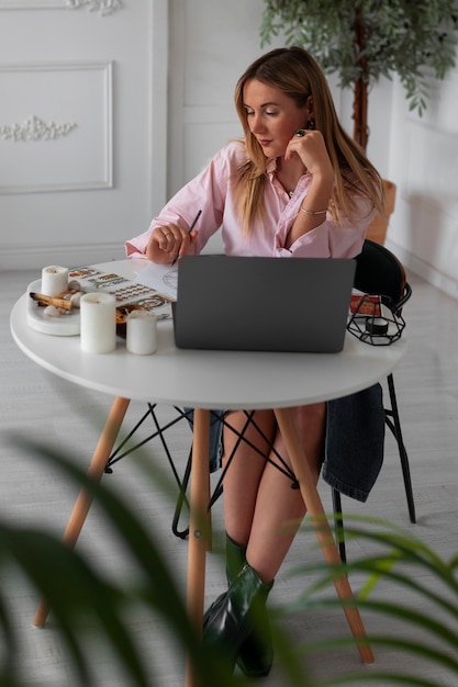 Full shot woman reading tarot with laptop