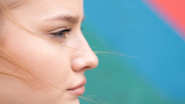 Young focused blonde woman outdoor training with multicolored background