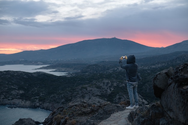 Man in Hoodie Standing on Mountain Hiking Trail