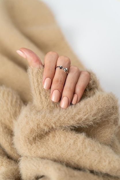 Graceful Thin Fingers of a Girl with Trendy Pastel Nude Manicure