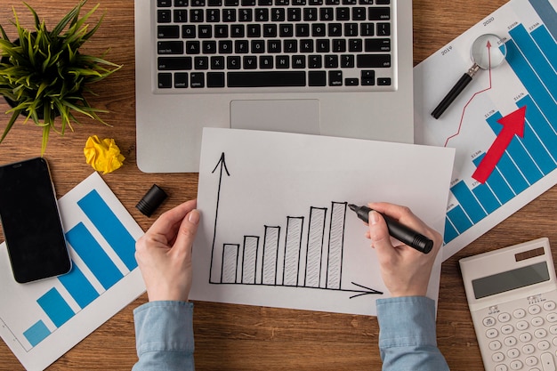 Top view of office desk with calculator and growth chart