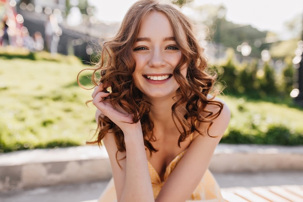 Dreamy Red-Haired Girl Posing with Sincere Smile on Nature