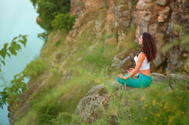 Youthful woman practicing yoga by the river – Free Download