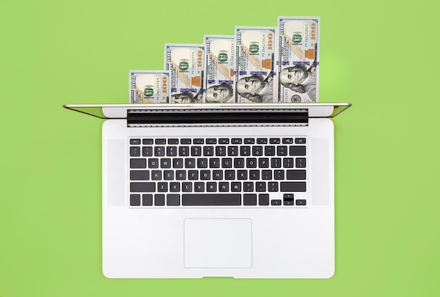 Laptop and dollar bills on color background flat lay – Free Stock Photo for Download