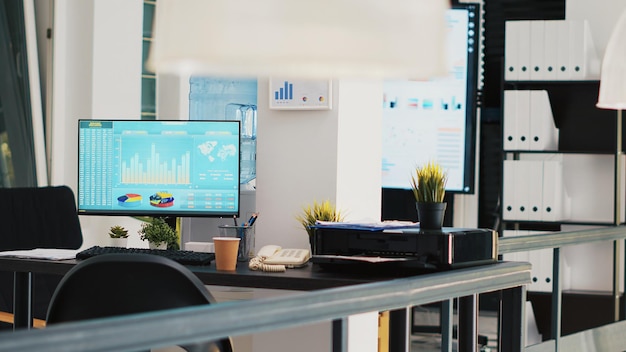 Office with stock exchange listings and business charts displayed in background