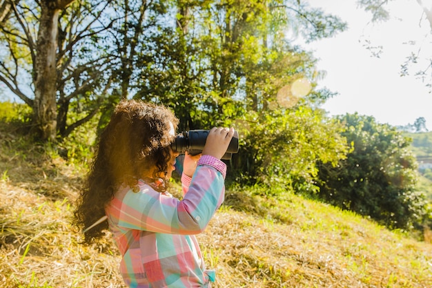 Young Girl on Hill with Binoculars