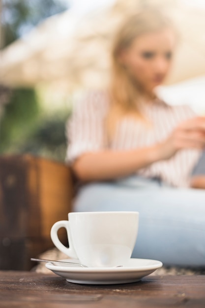 Cup of White Coffee with Saucer and Spoon on Wooden Table – Free Download