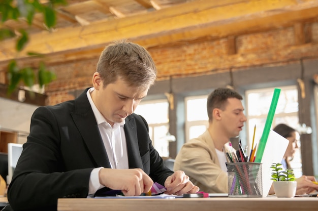 Colleagues working together in a office using modern devices during creative meeting