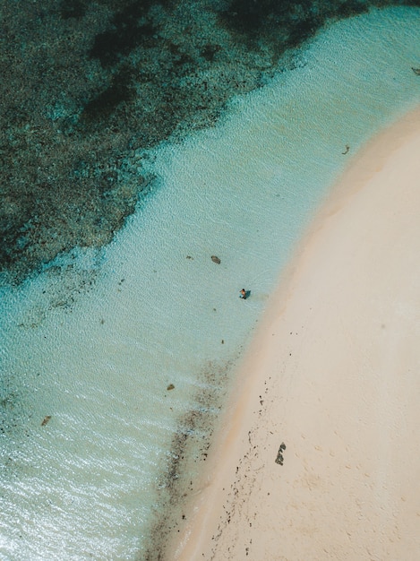 Aerial Shot of Ocean Waves Hitting Sandy Beach – Free Download