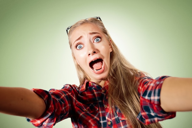 Young blonde woman taking selfie