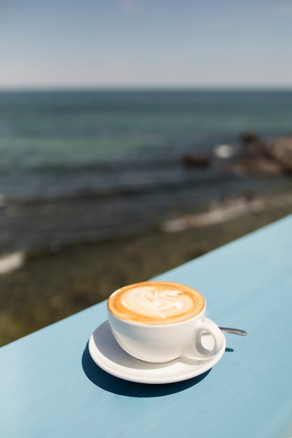 High Angle Coffee Cup Image at Seaside – Free Download