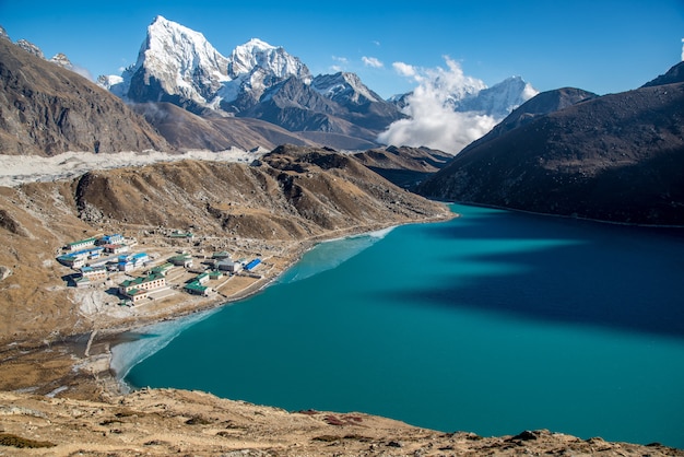 Scenic Small Town by Blue Body of Water Surrounded by Mountains