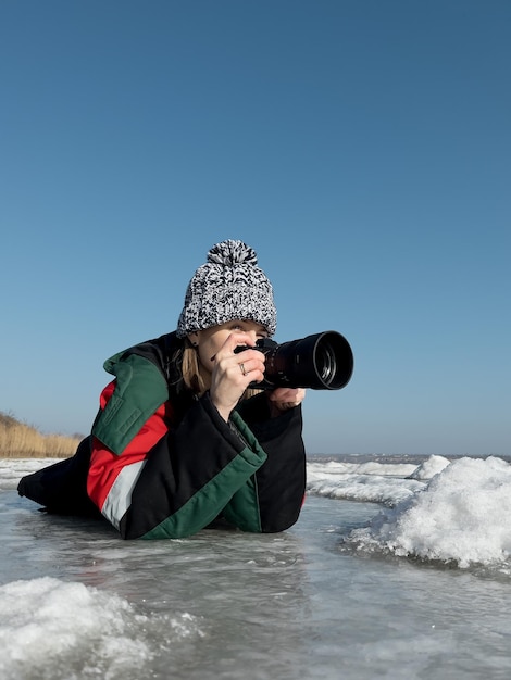 Woman photographer capturing images of winter landscape