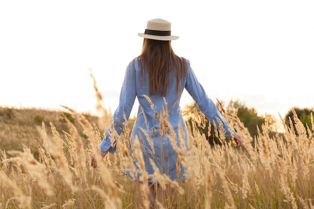 Back view of woman with hat posing through the fields – Free Stock Photo