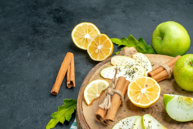 Bottom View of Green Apples, Cinnamon Sticks, Lemon Slices, and Apple Slices on Wood Board