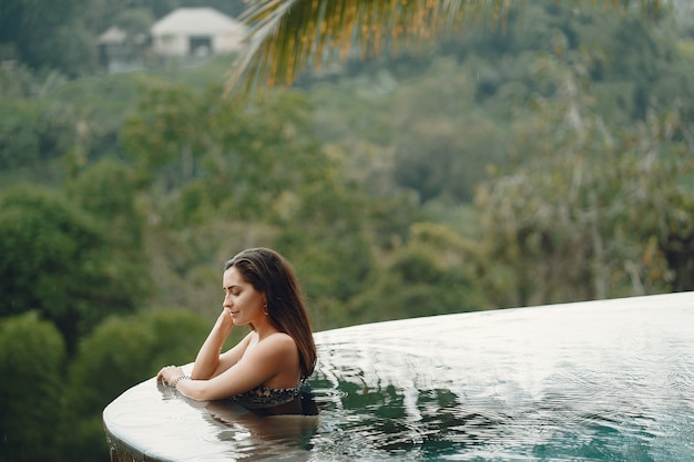 Woman in a swimming pool on a jungle view