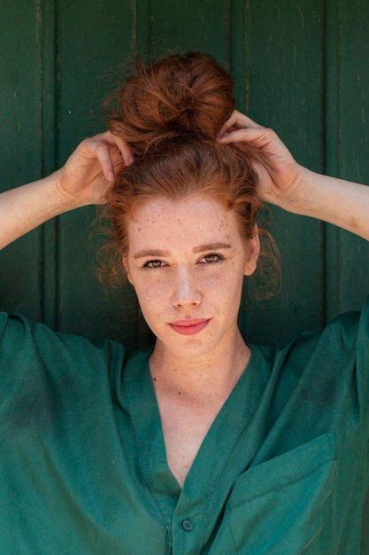 Young lady arranging her red hair