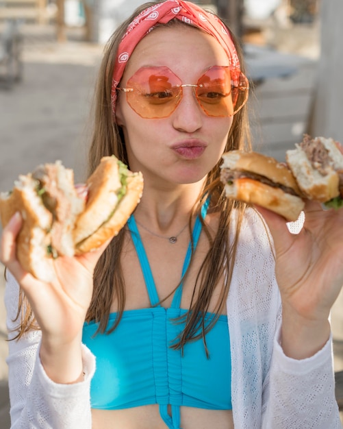 Woman Eating Burgers on the Beach