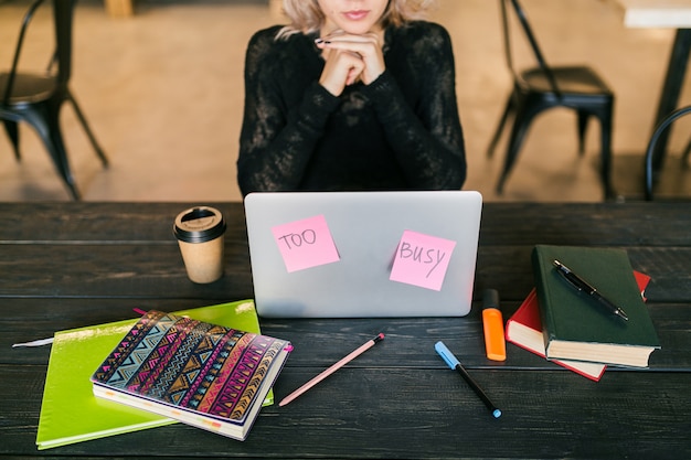 Busy Young Woman Working on Laptop with Paper Stickers in Classroom