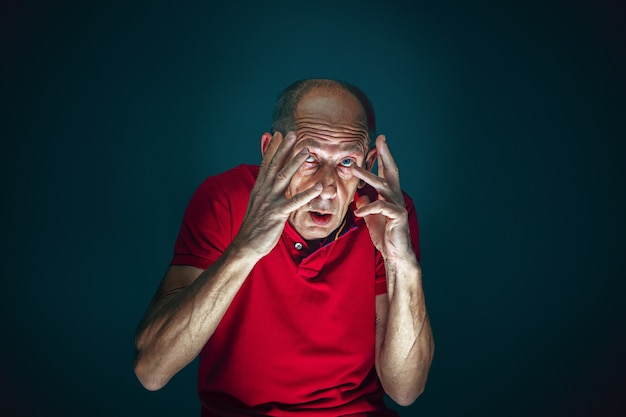 Close up portrait of crazy scared and shocked man isolated on dark