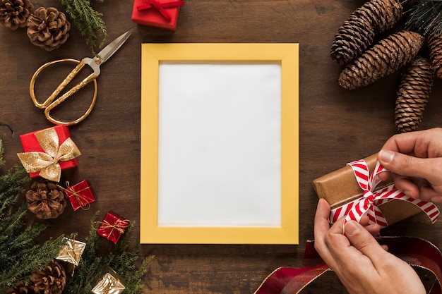 Person Tying Bow on Gift Box on Table