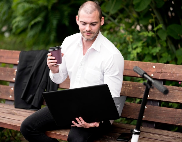 Portrait of businessman browsing laptop outdoors