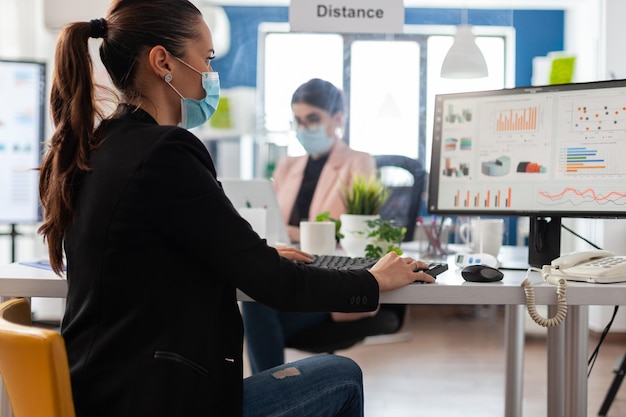 Teamwork in Corporate Office: Businesswomen Planning Company Presentation with Medical Face Masks