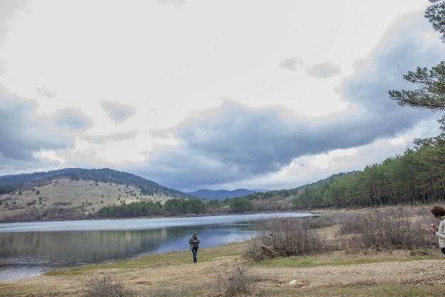 Girl standing near Lake Piva (Pivsko jezero) with mountain landscape on the distance