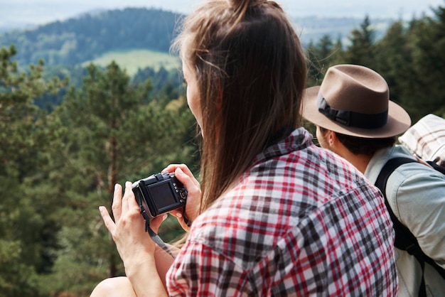 Side View of Backpacker Using Camera in the Mountains