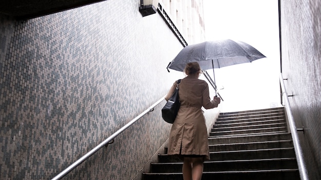 Woman going out in the city while it rains