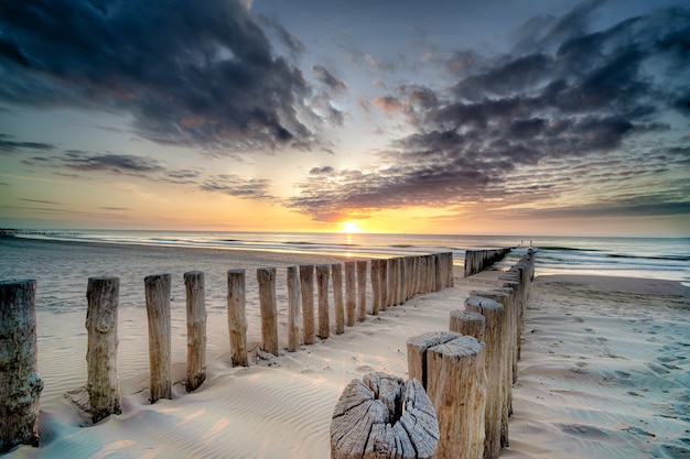 High Angle Shot of a Wooden Deck on the Shore Leading to the Sea at Sunset