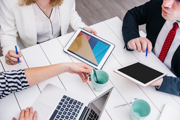 Crop Businesspeople Using Gadgets at Desk