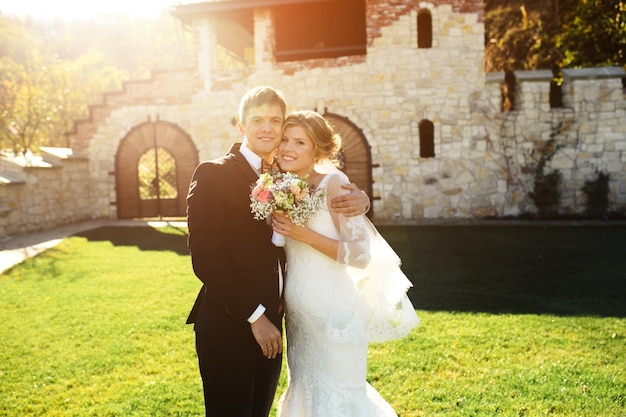 Happy newlyweds posing outdoors on a sunny day