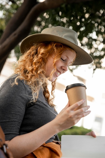 Woman on bench drinking coffee